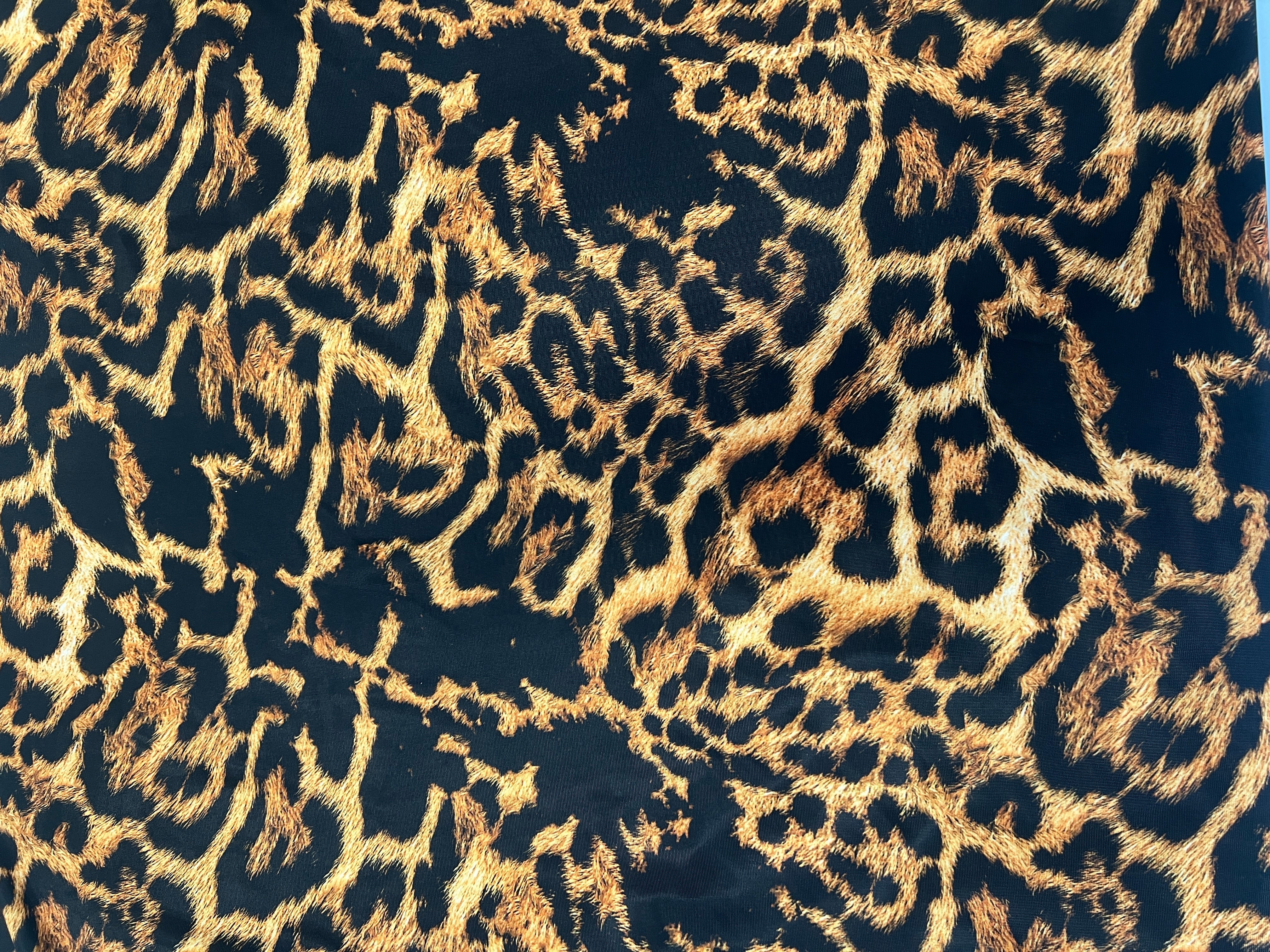 Black and brown leopard print slinky jersey fabric close-up